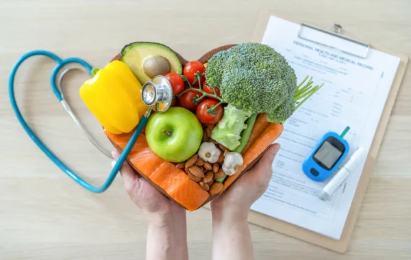 Foto de una manos sosteniendo frutas y verduras