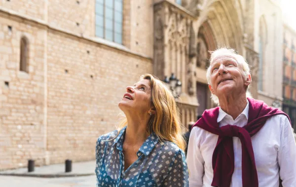 Foto de una pareja de adultos paseando por un casco histórico de una ciudad