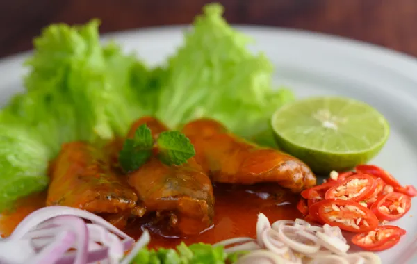 Foto de un plato de sardinas en un plato con ensalada