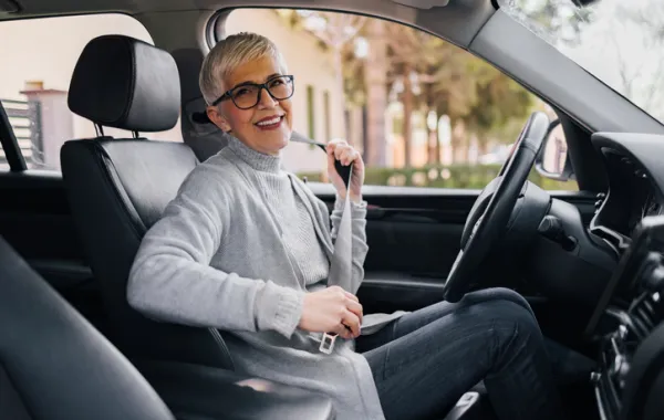 Foto de una mujer adulta en un cche abrochandose el cinturon