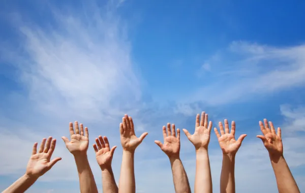 Foto de varias manos mirando al cielo