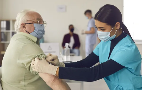 Foto de un señor mayor que está siendo vacunado