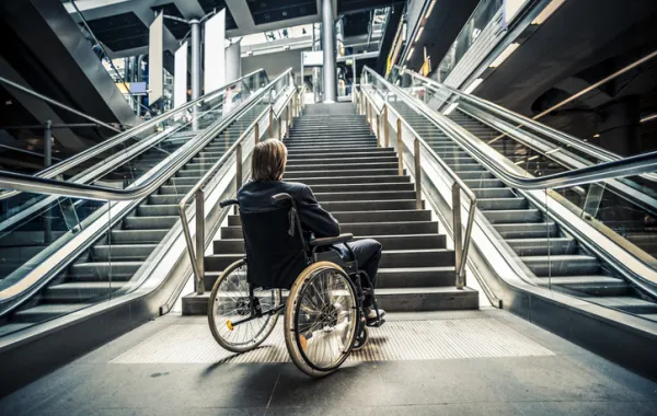Foto de una persona en silla de ruedas ante varias escaleras