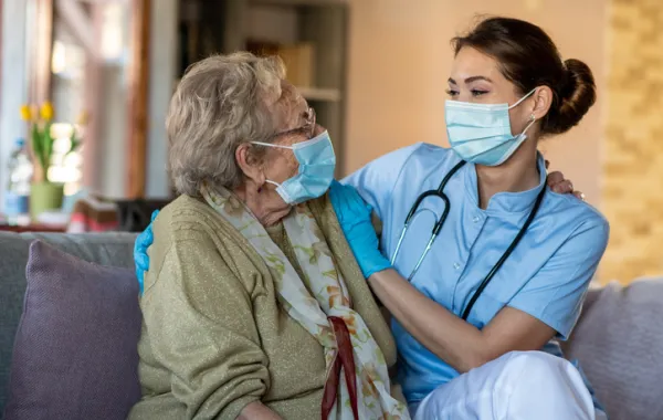 Foto de una asistente social acompañando a una señora mayor