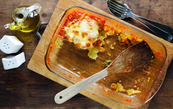 Foto de una bandeja de horno con una comida que le queda una parte en la bandeja