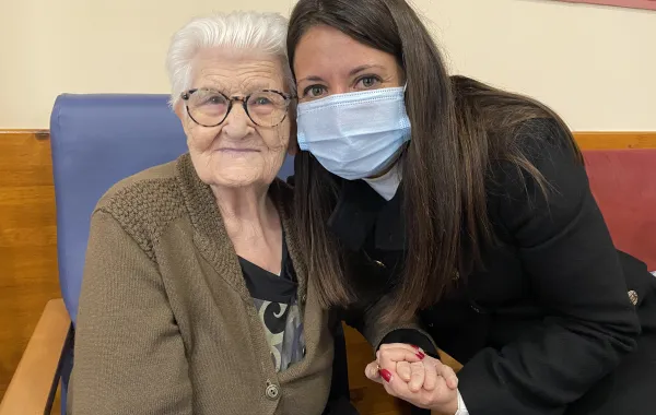 Foto de una señora mayor acompañada por una chica joven