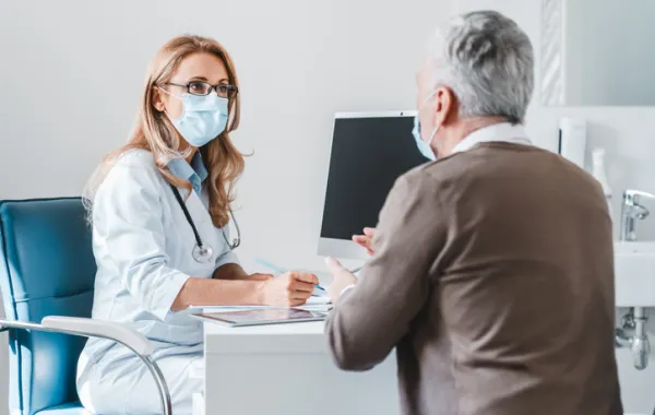 Foto de una doctora atendiendo a un paciente mayor