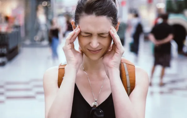 Foto de una chica joven tapándose los oidos por el ruido