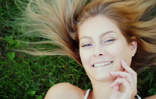 Foto de una mujer tumbada en la hierba y con el pelo suelto
