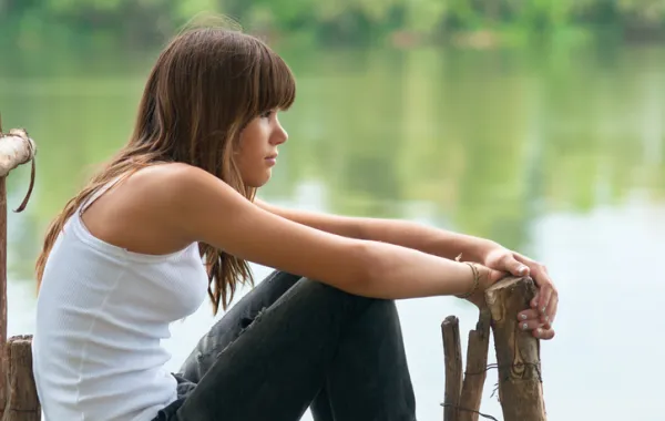 Foto de perfil de chica joven sentada con mirada cansada