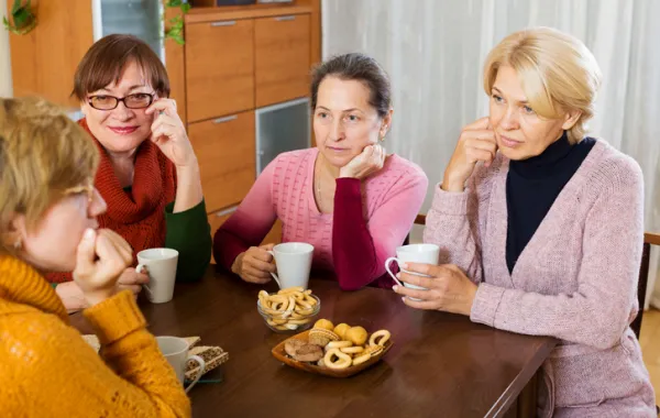 Foto de varias mujeres adultas tomando café en un salón de una casa