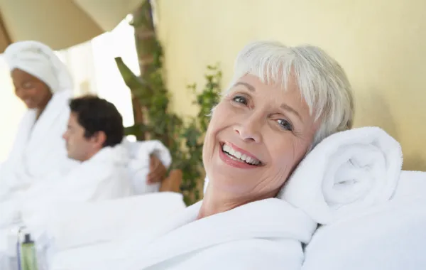 Foto mujer con pelo blanco y sonriente tumbada ligeramente en una almohada toalla