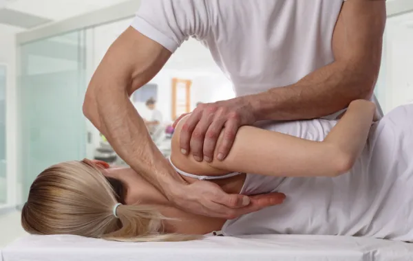 Foto de una mujer recibiendo un masaje de espalda por un fistioterapeuta