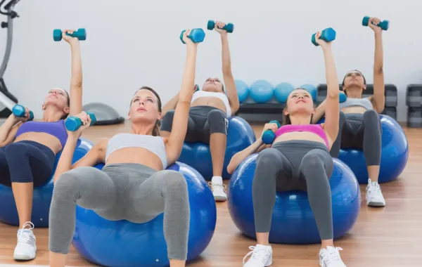 Foto de mujeres haciendo ejercicio encima de una pelota de salud