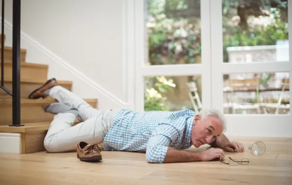 Foto hombre mayor caído en el suelo al final de una escalera