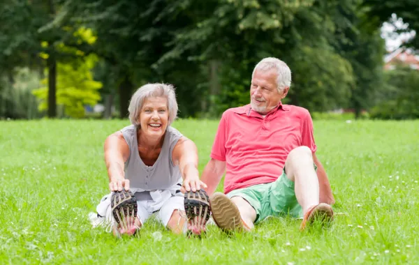 Foto de pareja adulta sentados en el cesped de un parque