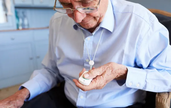 Foto de hombre mayor con un botón de teleasistencia