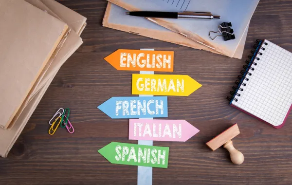 Foto con carteles mencionando distintos idiomas y con forma de flecha 