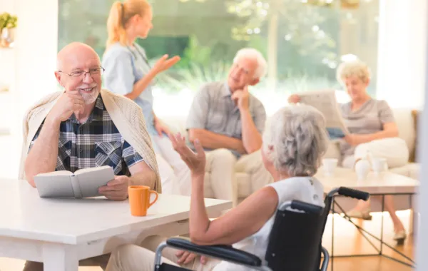 Foto de un grupo de personas mayores charlando con una enfermera