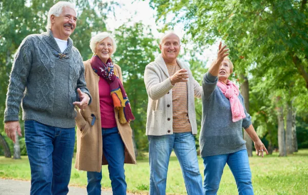 Foto de dos parejas de personas mayores sonriendo mientras pasean