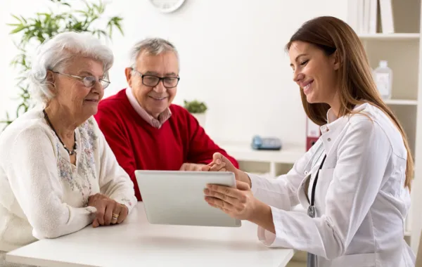 Foto de mujer asesorando a una pareja de personas mayores