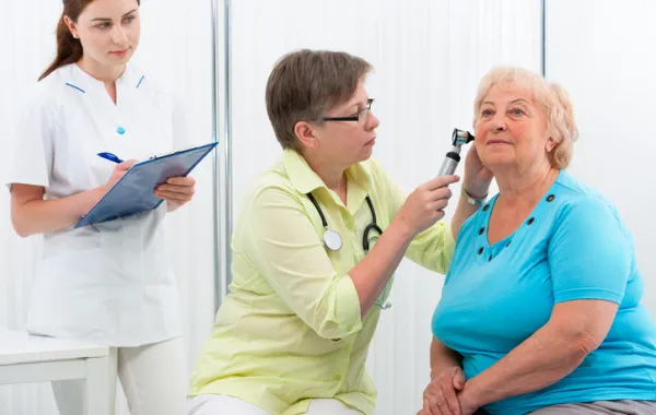 Foto de mujer mayor en una revisión de oidos de un medico