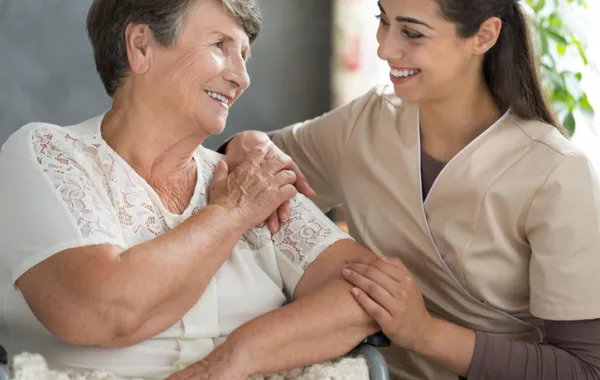 Foto de mujer mayor acompañada por una enfermera