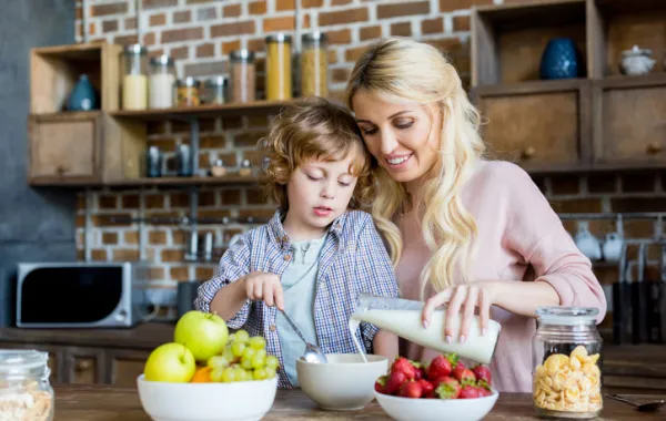 Foto de madre e hijo comiendo fruta y leche