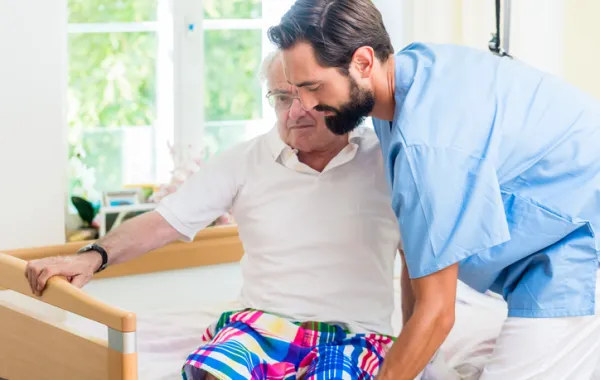 Foto de señor anciano ayudado por un enfermero joven