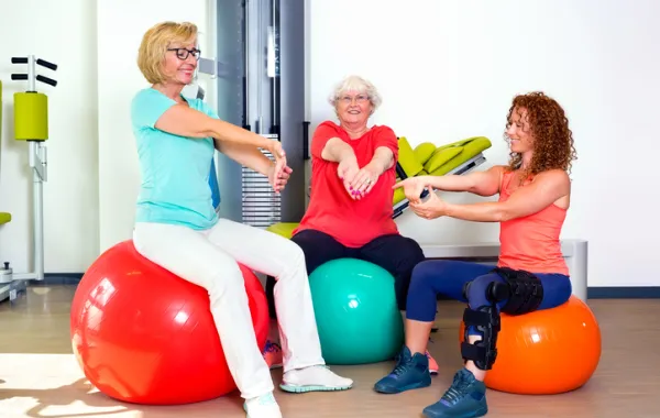 Foto de dos mujeres mayores haciendo ejercicio con una mujer joven