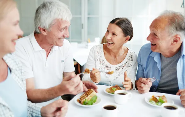 Foto de varias personas de edad madura tomando café y riendo