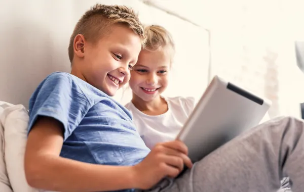 Foto de dos niños menores mirando una tablet