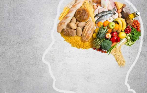 Foto de un gráfico de una cabeza de lado con el cerebro lleno de verduras y frutas