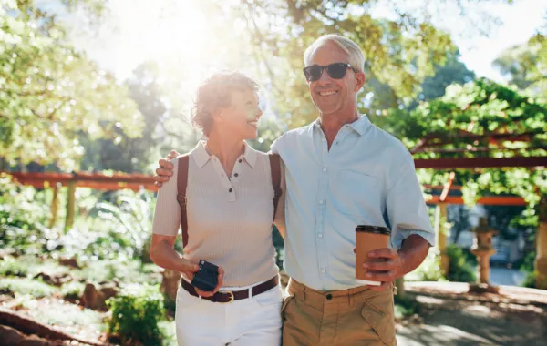 Foto de una pareja en edad madura paseando por un jardin