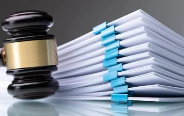 Fotografía de un mazo de juez junto a archivadores