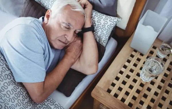 Hombre mayor durmiendo en su cama