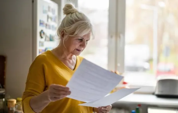 Mujer con expresión concentrada revisando documentación en papel