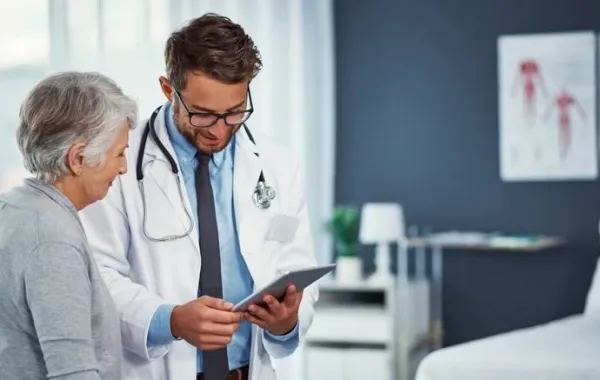Paciente mayor junto a su médico en la consulta