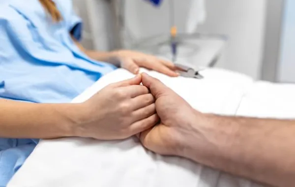 Trabajador social sujeta la mano de un paciente