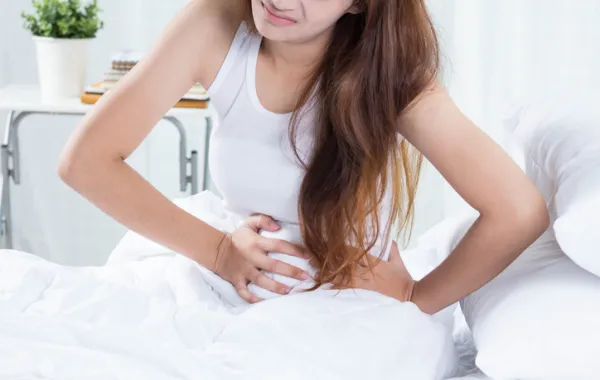 Foto de mujer que se pone la mano con dolor en la zona del bajo vientre