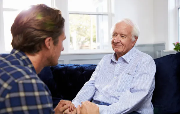 Foto de hombrea anciano hablando con un hombre joven