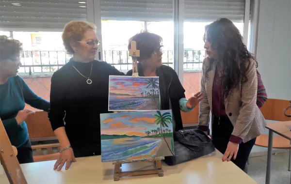 Foto de la consejera visitando varias mujeres en una clase de pintura