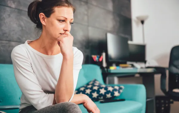 Foto de mujer mirando el suelo con mirada triste y ausente