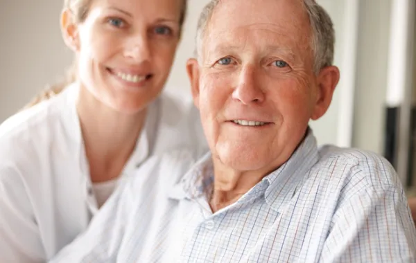Foto de un hombre mayor acompañado por una asistente social