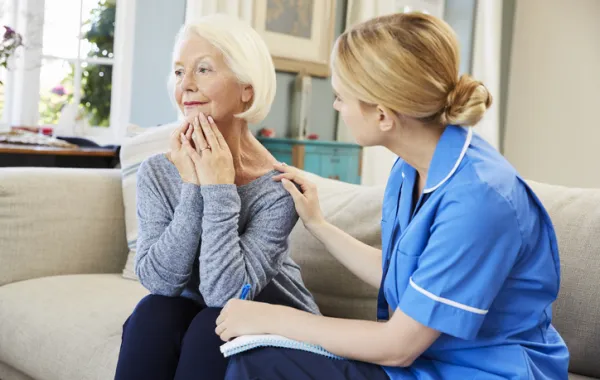 Foto de una mujer mayor sentada hablando con una asesora