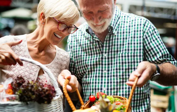 Foto de una pareja madura que llevan una bolsa con la compra del mercado