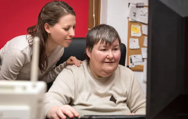 Foto de una mujer aprendiendo a utilizar un ordenador con una mujer joven