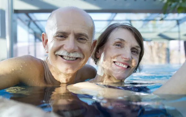 Foto de una pareja mayor en una piscina para tratamiento de termalismo