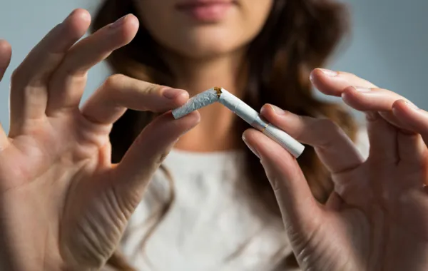 Foto de una mujer que rompe un cigarrillo