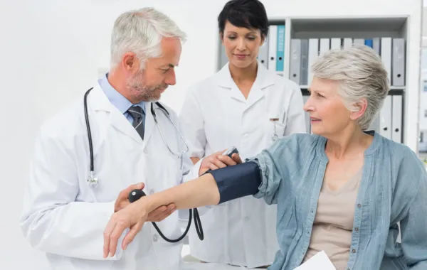 Foto de una mujer mayor atendida por un médico y una enfermera